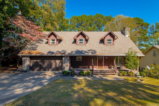 cape cod-style house featuring covered porch, a front yard, and a garage