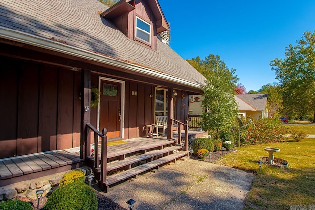 entrance to property with covered porch and a lawn