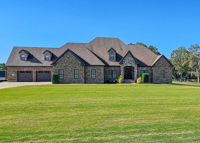 french country style house with a front yard and a garage