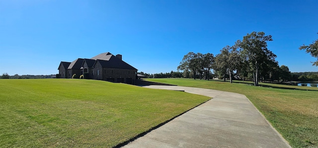 view of community with a water view and a lawn