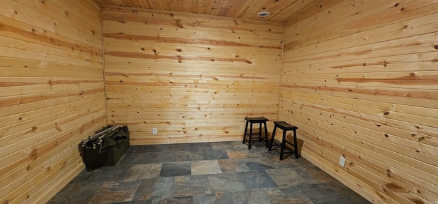 unfurnished room featuring wood ceiling and wood walls