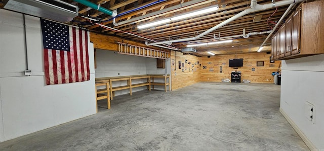 basement with wooden walls and a workshop area