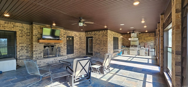 view of patio featuring ceiling fan, grilling area, and exterior kitchen