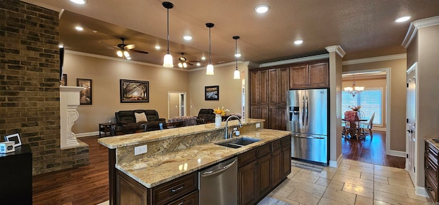 kitchen with a spacious island, dark brown cabinets, ornamental molding, sink, and appliances with stainless steel finishes