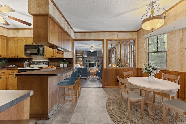 kitchen featuring ceiling fan, a textured ceiling, white range oven, and a fireplace