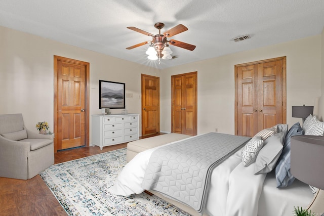 bedroom featuring a textured ceiling, wood-type flooring, and ceiling fan