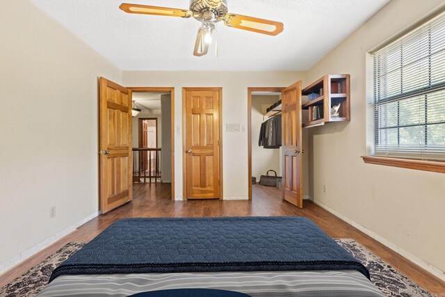 bedroom featuring dark hardwood / wood-style flooring, a textured ceiling, and ceiling fan