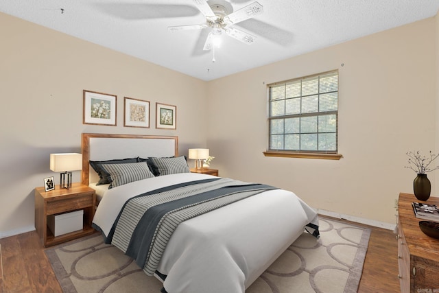 bedroom featuring a textured ceiling, wood-type flooring, and ceiling fan