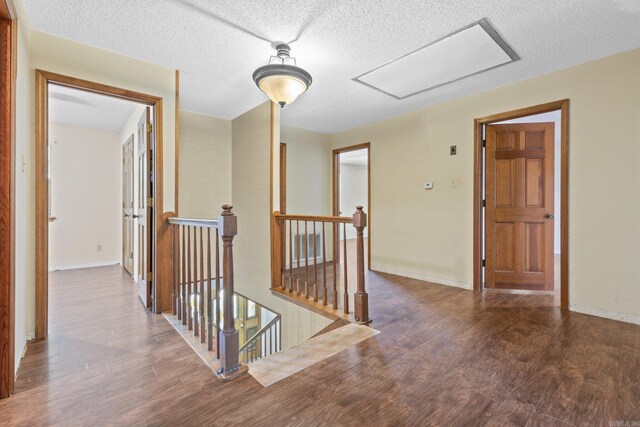 hall featuring hardwood / wood-style flooring and a textured ceiling