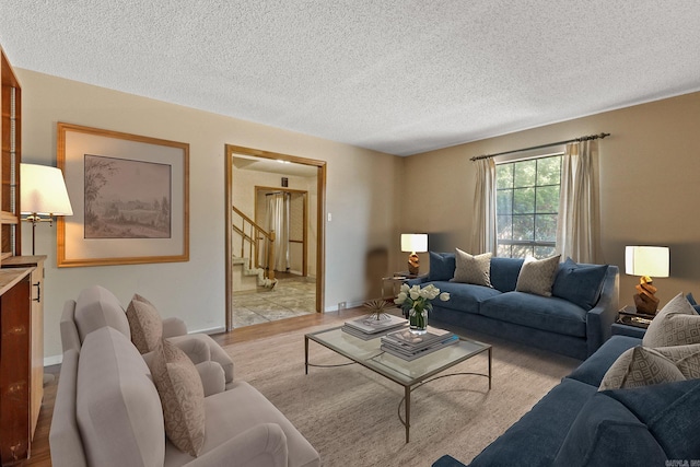 living room with a textured ceiling and light wood-type flooring