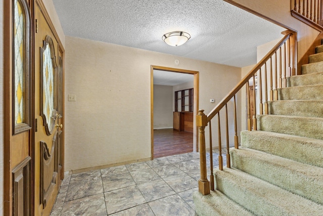 entrance foyer featuring a textured ceiling and light wood-type flooring