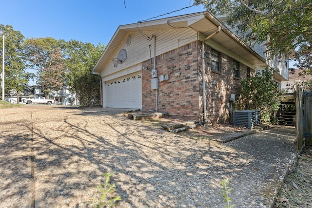 view of side of property featuring cooling unit and a garage