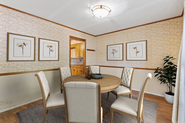 dining area featuring crown molding, hardwood / wood-style floors, and a textured ceiling