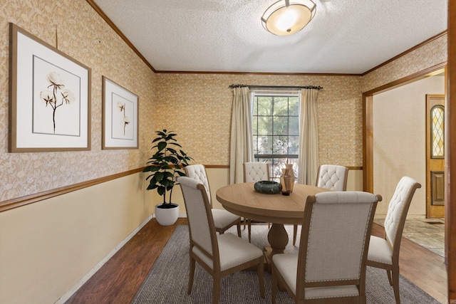 dining room with crown molding, hardwood / wood-style floors, and a textured ceiling