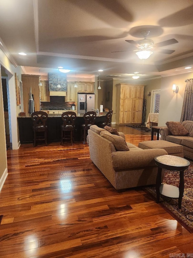 living room with crown molding, dark hardwood / wood-style floors, and ceiling fan