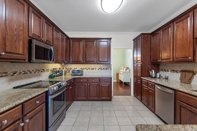 kitchen with light stone counters, crown molding, appliances with stainless steel finishes, and tasteful backsplash