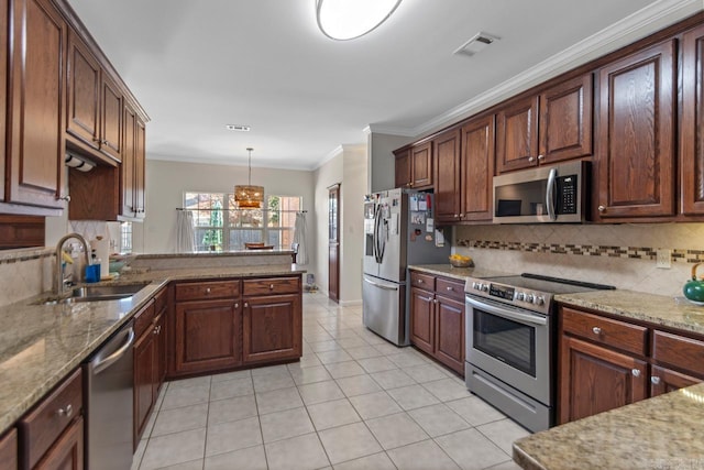 kitchen featuring hanging light fixtures, light stone counters, appliances with stainless steel finishes, ornamental molding, and sink