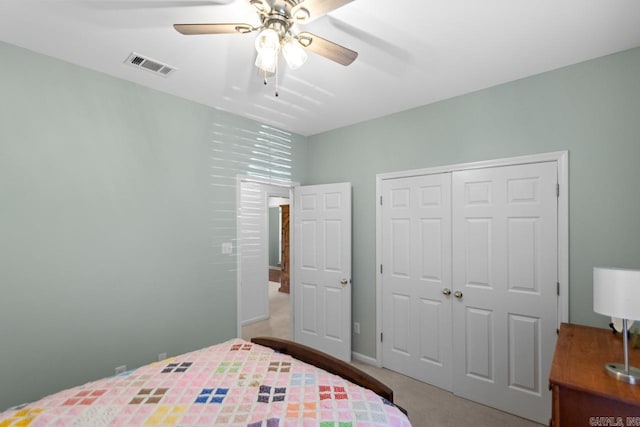 bedroom with a closet, ceiling fan, and light colored carpet