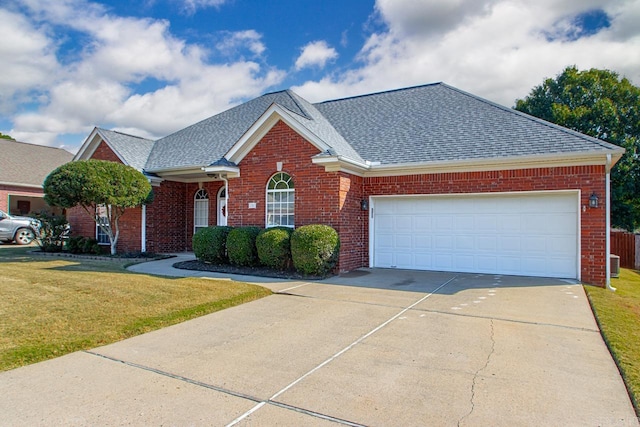 view of front facade with cooling unit, a garage, and a front lawn