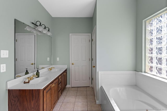 bathroom with vanity, a bathtub, a healthy amount of sunlight, and tile patterned flooring