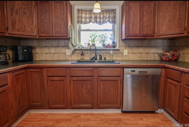 kitchen featuring decorative backsplash, light wood-type flooring, dishwasher, pendant lighting, and sink