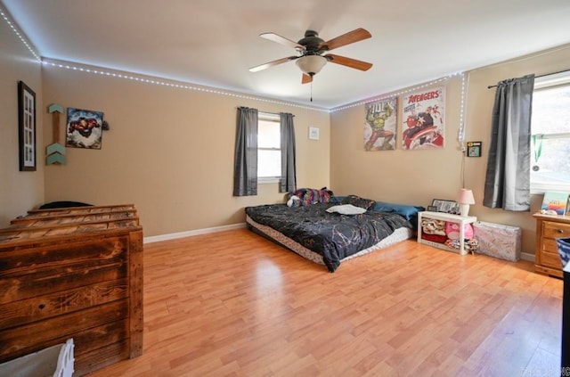 bedroom featuring multiple windows, light wood-type flooring, and ceiling fan