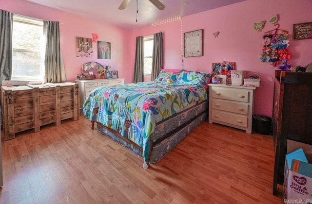 bedroom with multiple windows, light wood-type flooring, and ceiling fan