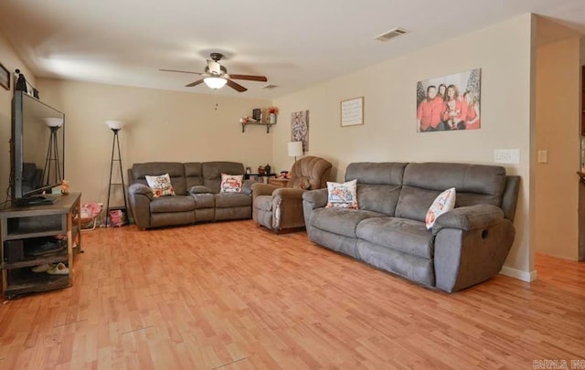 living room featuring light hardwood / wood-style flooring and ceiling fan