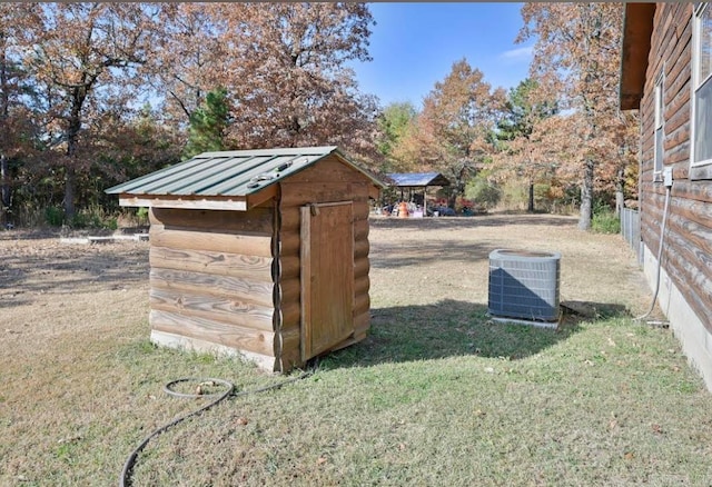 view of outbuilding featuring a yard and central air condition unit