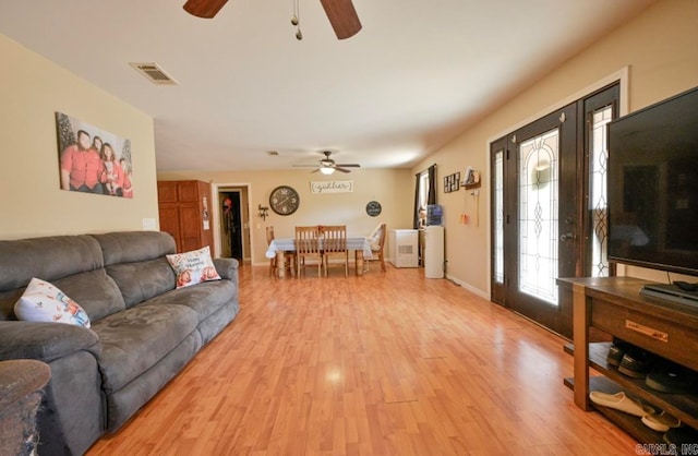 living room featuring light hardwood / wood-style flooring and ceiling fan