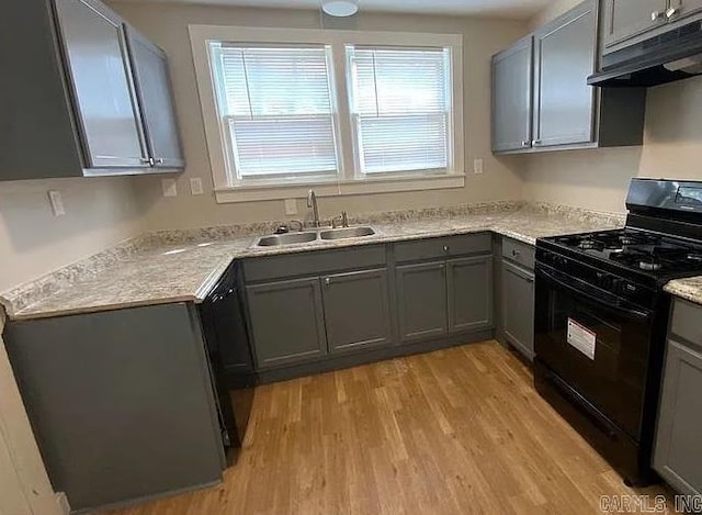 kitchen with gas stove, light hardwood / wood-style flooring, sink, and gray cabinets