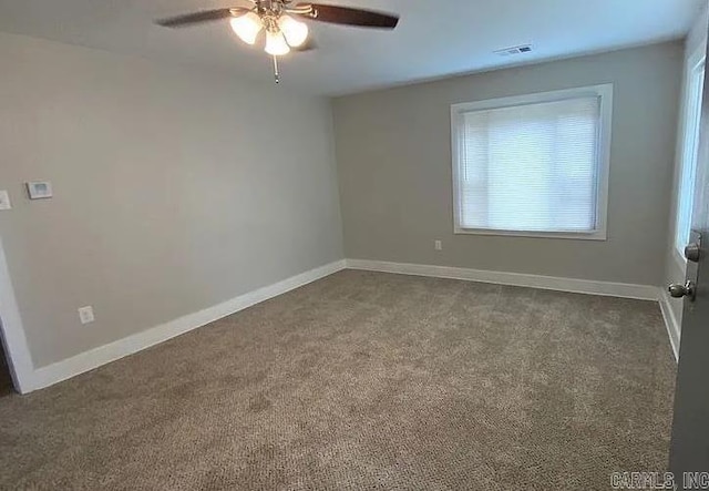 carpeted spare room featuring ceiling fan