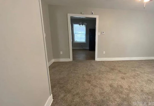 unfurnished room with ceiling fan and dark colored carpet