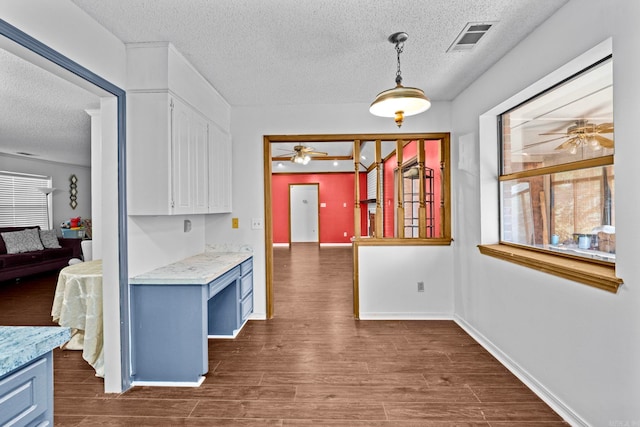 kitchen featuring dark wood-type flooring, ceiling fan, a textured ceiling, and decorative light fixtures