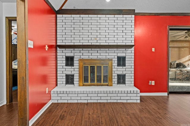 unfurnished living room with a textured ceiling, hardwood / wood-style flooring, and a fireplace