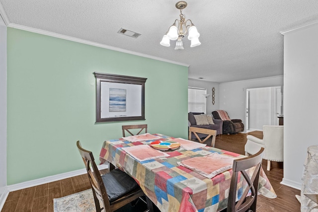 dining area with crown molding, a textured ceiling, a chandelier, and dark hardwood / wood-style floors