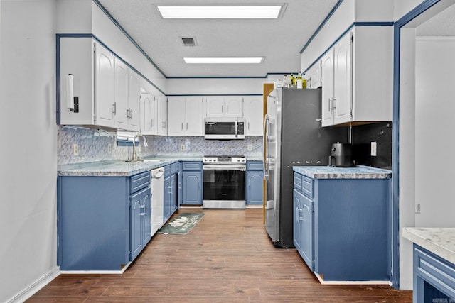 kitchen featuring a textured ceiling, hardwood / wood-style flooring, stainless steel appliances, and sink