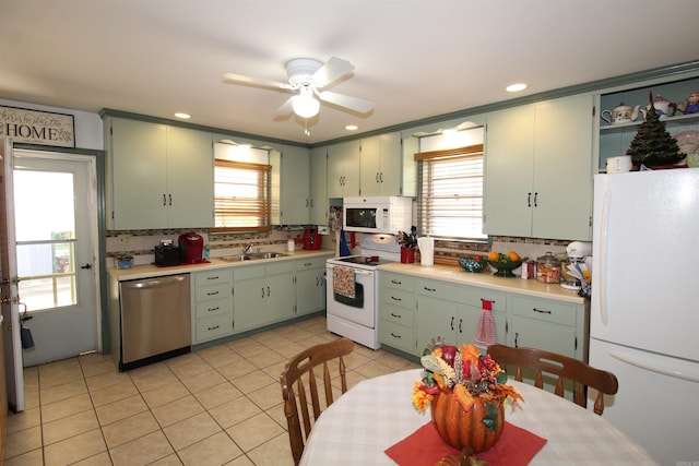 kitchen featuring white appliances, a wealth of natural light, light countertops, and a sink