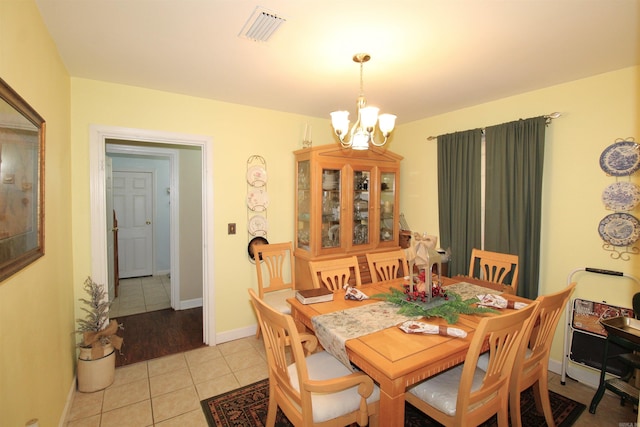 tiled dining space with a chandelier