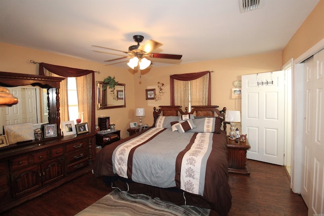 bedroom featuring a ceiling fan, visible vents, and dark wood-style flooring