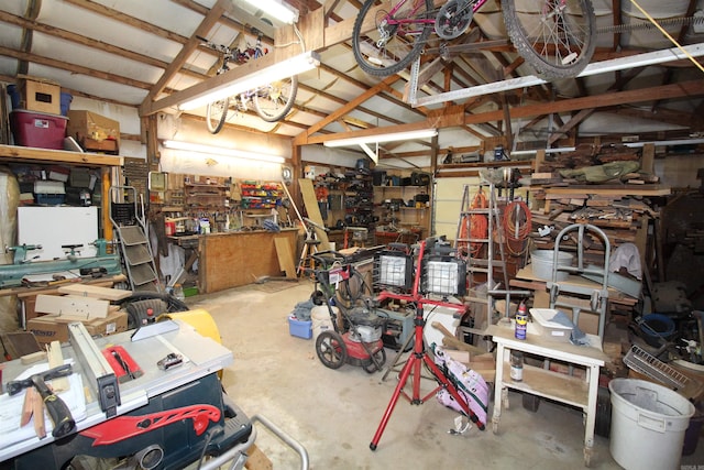 misc room featuring a workshop area, lofted ceiling, and concrete flooring