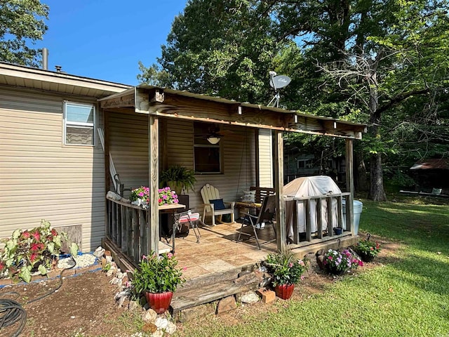 wooden deck featuring a patio area, a grill, a lawn, and ceiling fan