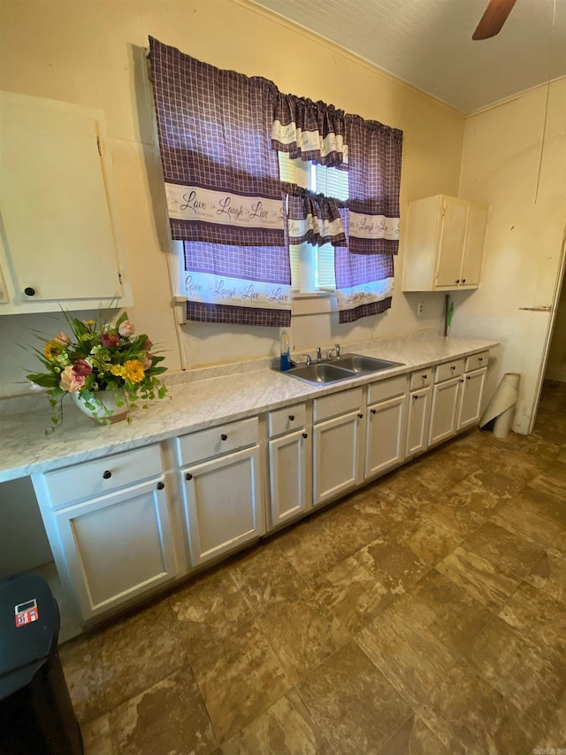 kitchen featuring sink, white cabinetry, and ceiling fan