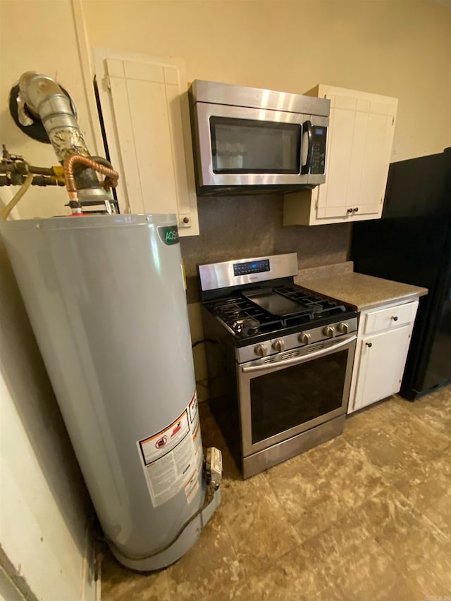 kitchen featuring water heater, white cabinets, and stainless steel appliances