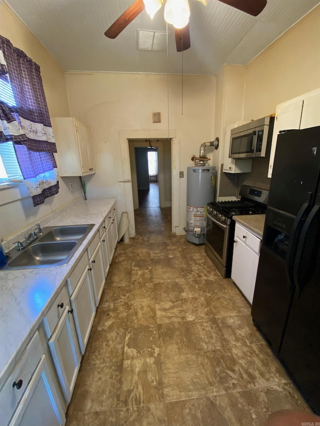 kitchen with ceiling fan, appliances with stainless steel finishes, gas water heater, white cabinetry, and sink