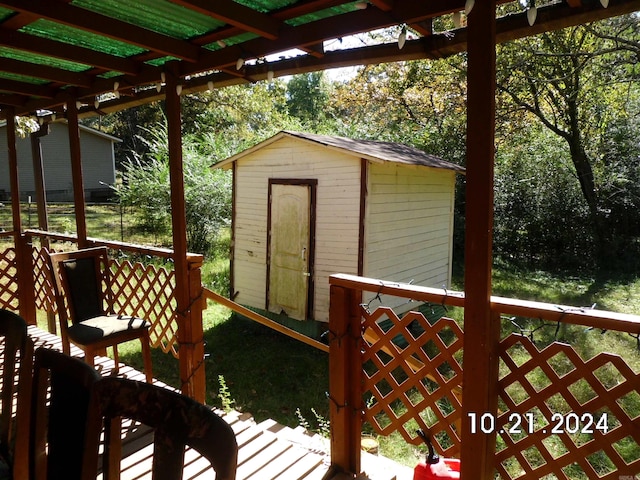 wooden deck featuring a shed and a pergola