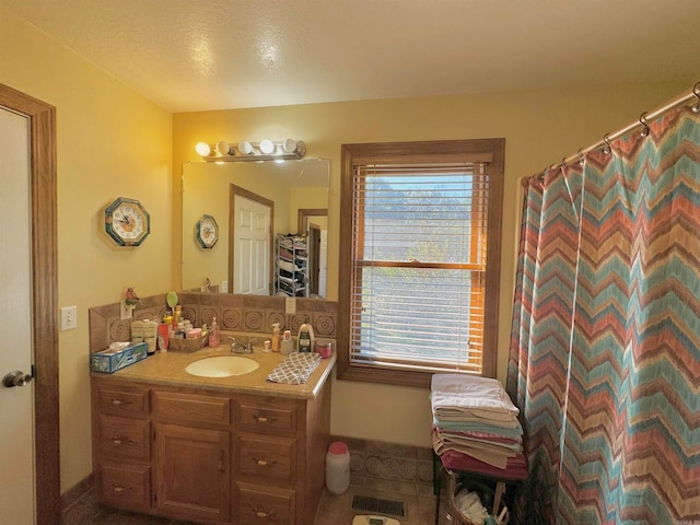 bathroom featuring vanity, a textured ceiling, and a healthy amount of sunlight