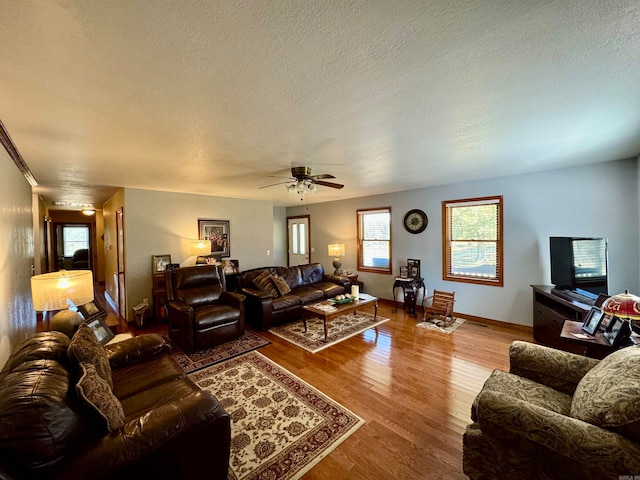 living room featuring a textured ceiling, hardwood / wood-style flooring, and ceiling fan