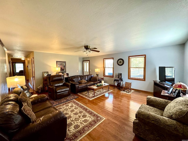 living room featuring a textured ceiling, hardwood / wood-style flooring, and ceiling fan