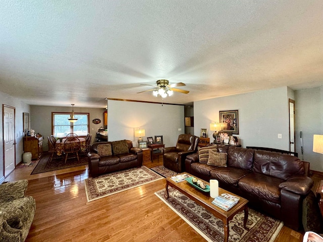 living room with ceiling fan, a textured ceiling, and hardwood / wood-style floors